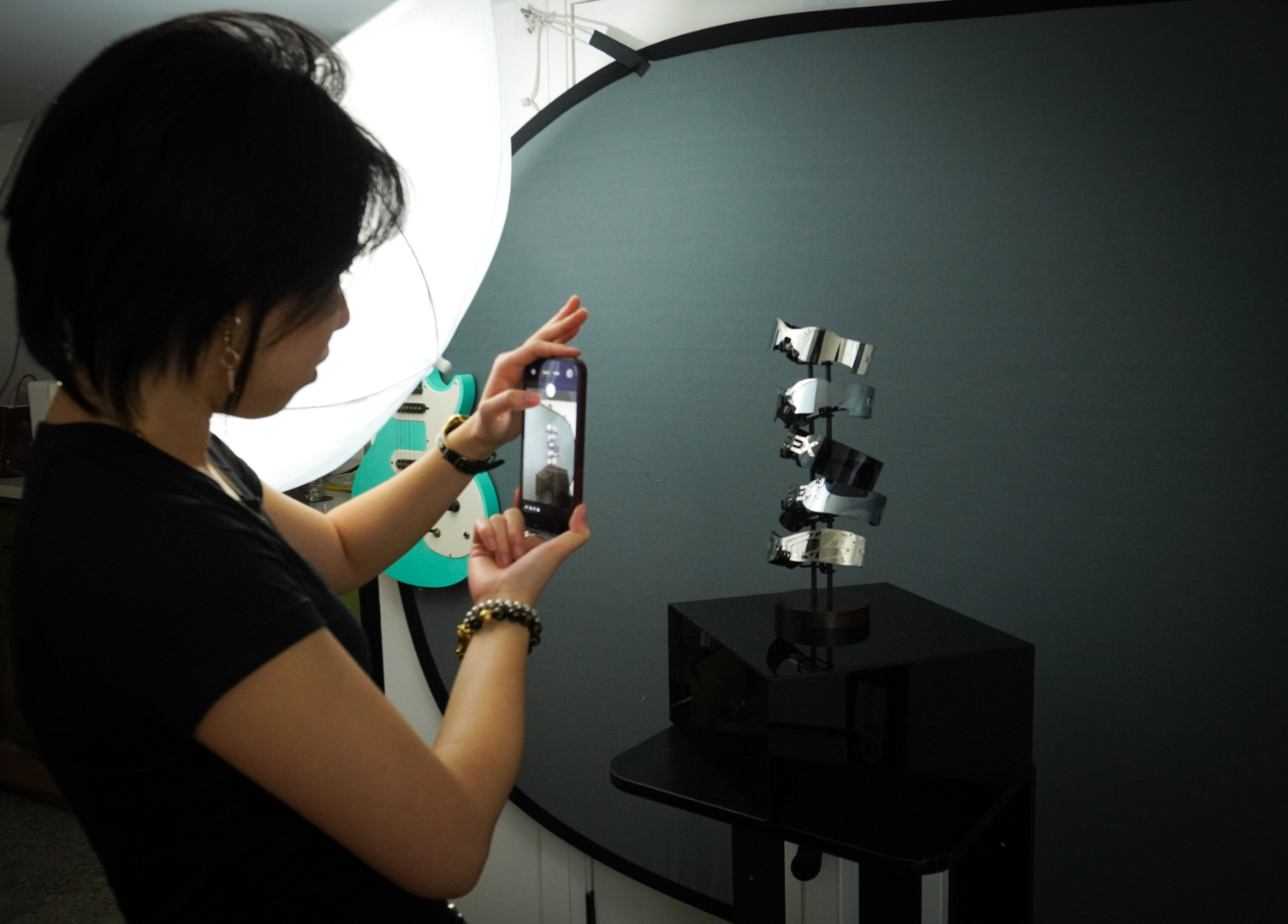 Kyra Tang photographing accessories with a phone and studio lighting
