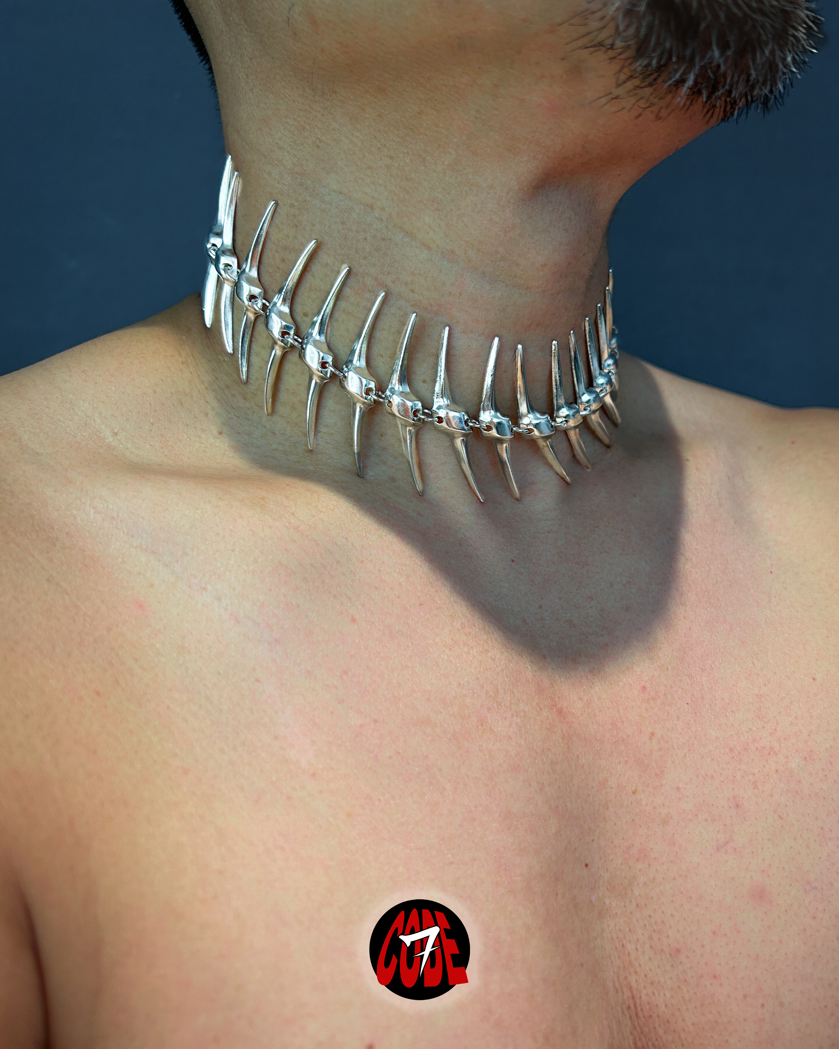 A silver coloured skeletal choker worn around a model’s neck